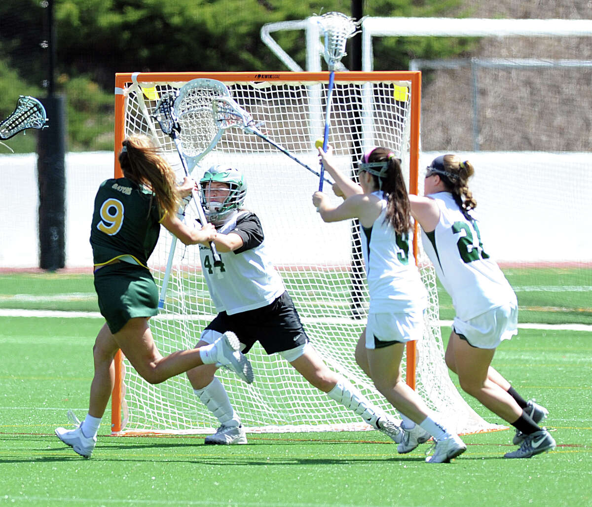 Greenwich Academy’s Karina Schulze, left, scores a first-half goal past Sacred Heart goalie Maddie McLane while being defended by Sacred Heart’s Emily Micciulli, 9, and Ellen Purcel at Greenwich Academy on Saturday. Schulze scored five goals and Greenwich Academy won 12-9.