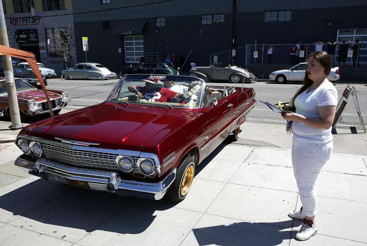 Freshman Devianna Roca checks in a vehicle during the Give Something Back Car Show at John O'Connell High School in San Francisco, California, on Sunday, May 1, 2016.