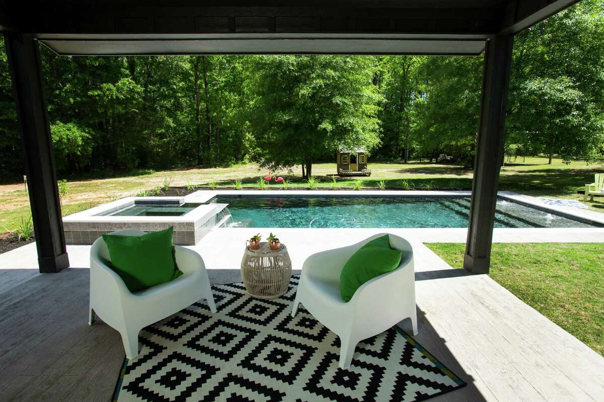 Just off the kitchen and dining area, a covered deck leads to the pool behind the house.