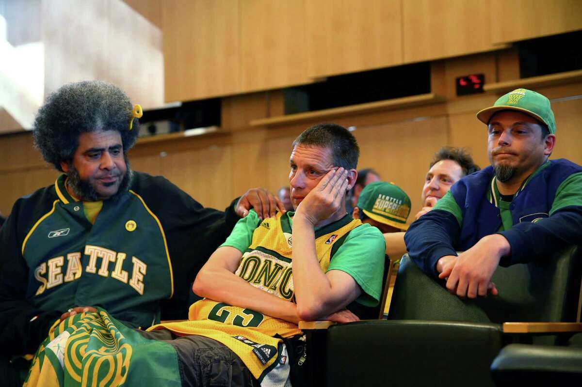 Seattle SuperSonics fans Kris "Sonics Guy" Brannon, left, Kenneth Knutsen, center, and Jason Billingsley react to the Seattle City Council's 5-4 no vote against a "street vacation" vacating stretch of road where investor Chris Hansen hopes to eventually build an arena that could house an NBA and NHL team.