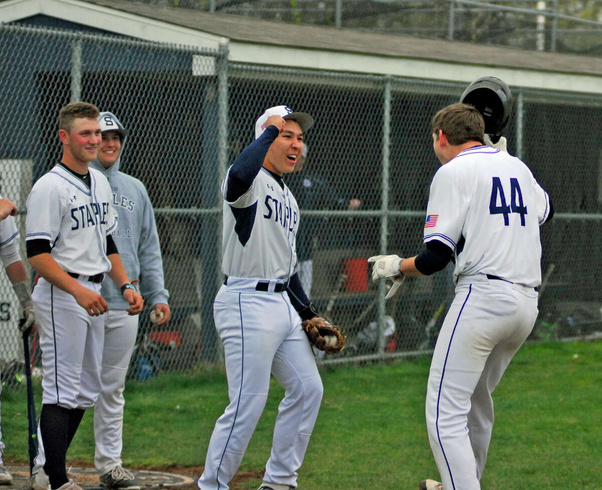 Staples' Chad Knight, center, celebrates with Michael Fanning, right, after Fanning hit one of two home runs in a 10-2 win over Norwalk on Monday.
