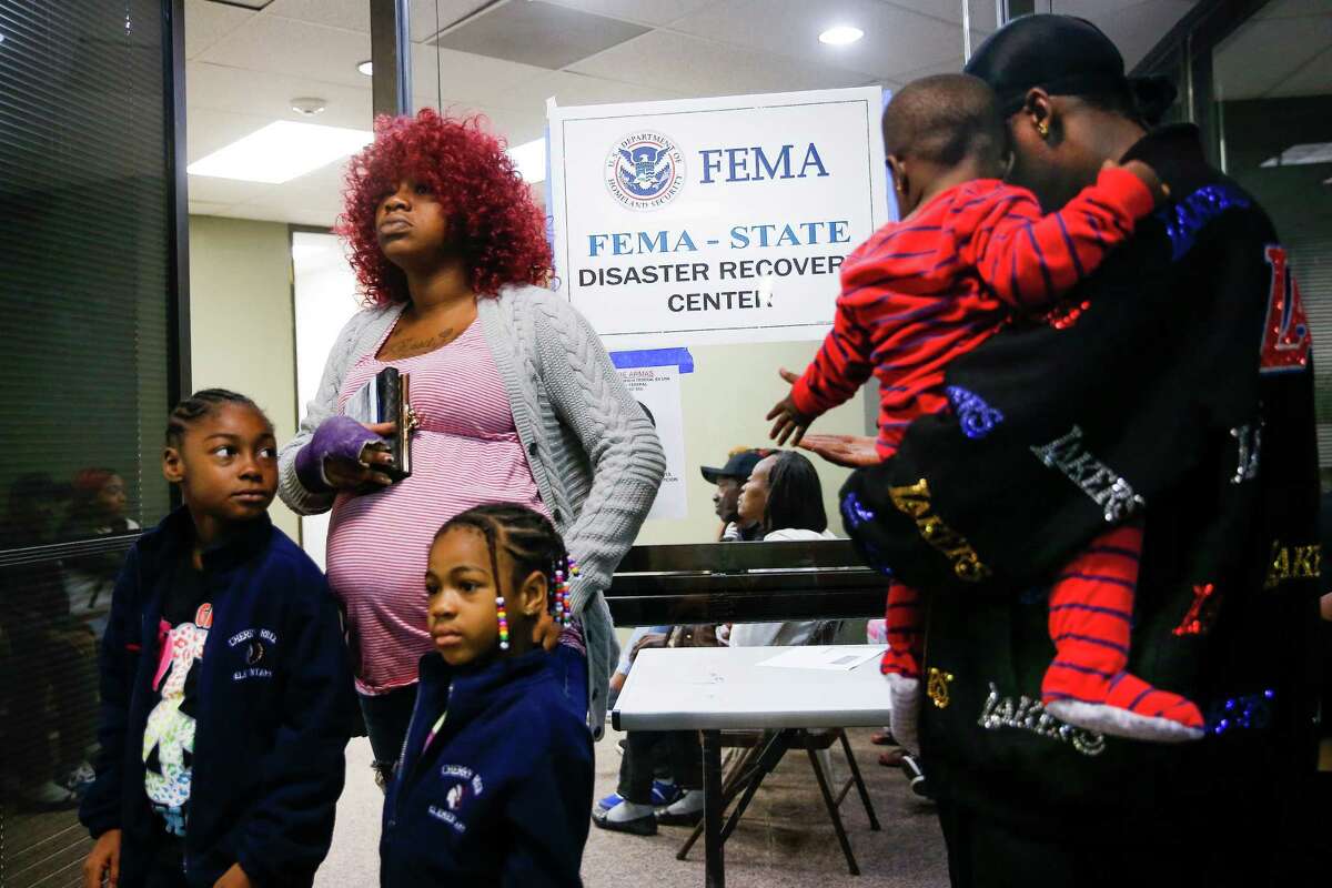 Jennifer Ukeju waits with daughters Satteriyah, 7, left, Shamarriyah, 5, and fiancé Patrick Hill and his son, Levi, 1, for a center to open.