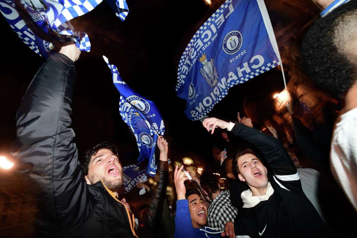 Fans in Leicester City, a town of 330,000 in eastern England, wave flags as they celebrate their team becoming the English Premier League champions.