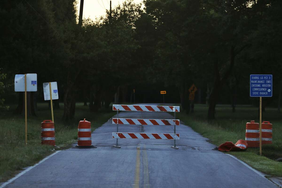 Barriers block Groeschke Road next to Addicks Reservoir Wednesday morning. A car was found Tuesday night near Groeschke Road by two kids riding bikes in the park and officials found a body in the car when they arrived. They believe the man had been living in his car and died during the floods. 