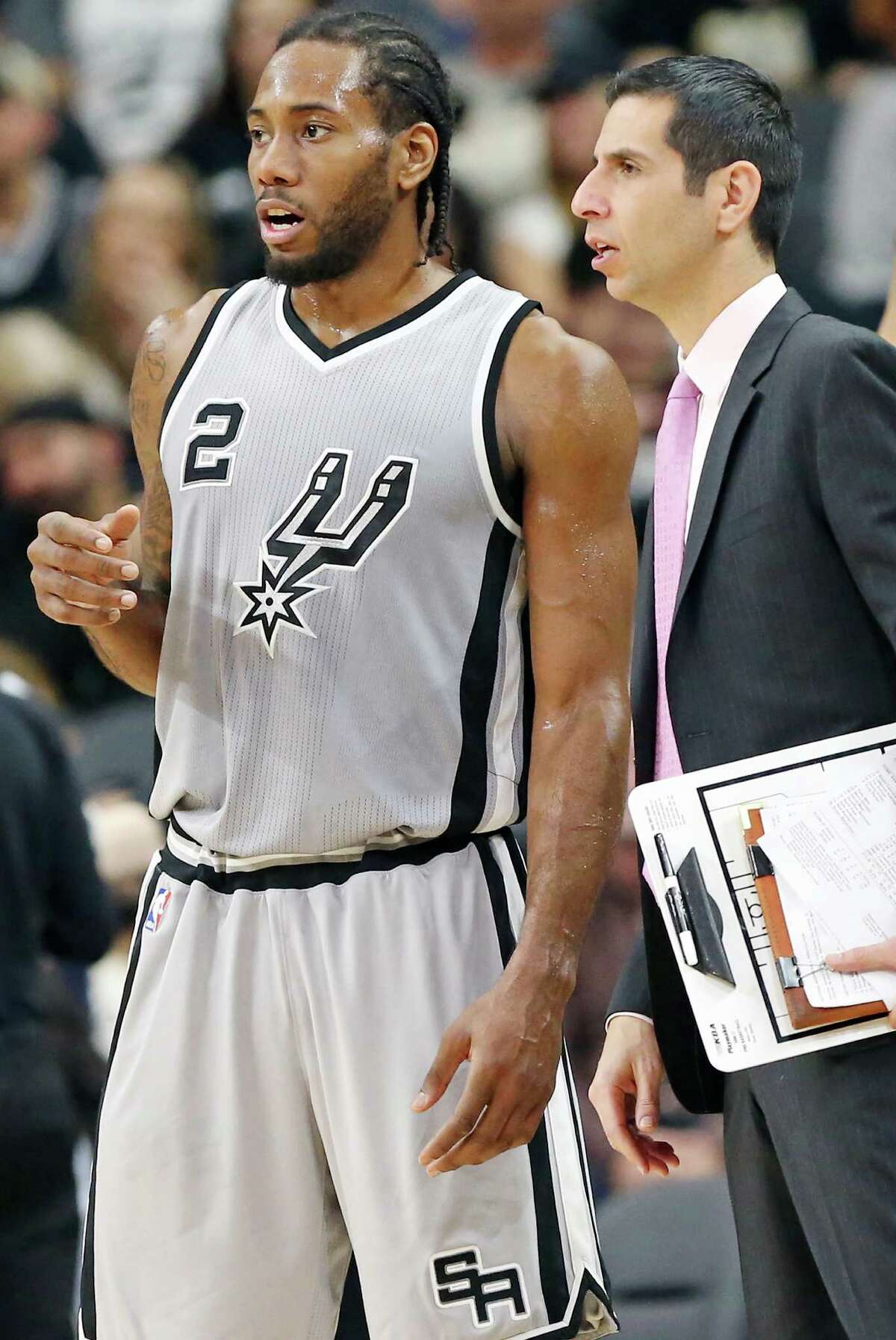 San Antonio Spurs' Kawhi Leonard talks with assistant coach James Borrego during second half action Saturday Jan. 2, 2016 at the AT&T Center. The Spurs won 121-103.