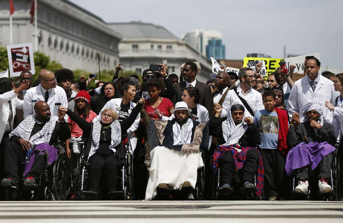 Hunger strikers arrive at City Hall in wheelchairs Tuesday.