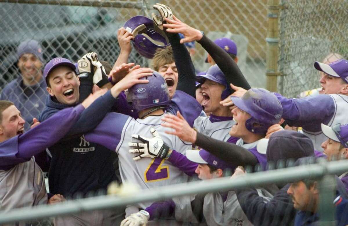 Westhill High School's #2 Tyler Rich is congratulated by the team as he runs across home plate after hitting a grand slam during a boys baseball game against Staples High Schoolin Stamford, Conn on April 16, 2010.