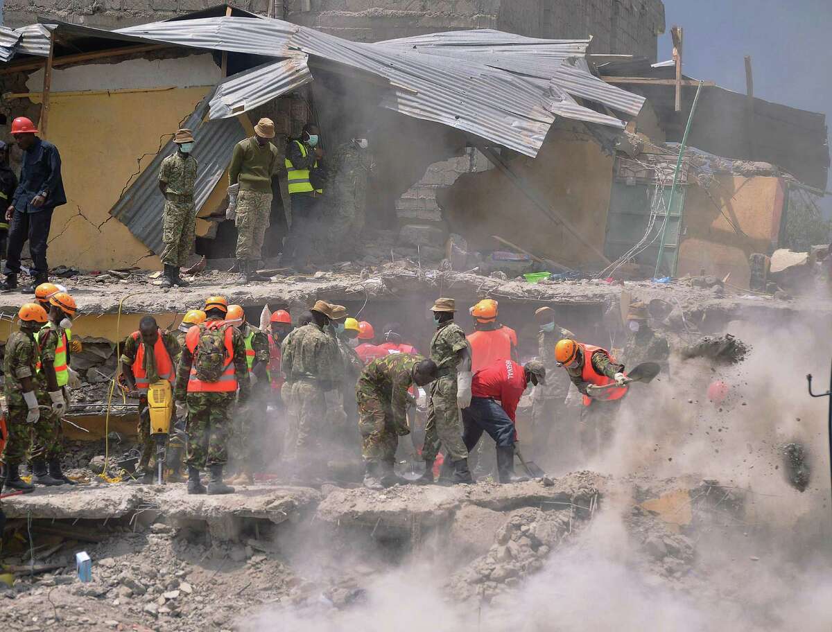 Rescue and medical personnel try to free a woman (unseen) who discovered alive May 5, 2016 in Nairobi after being trapped for six-days in the rubble of a residential house that collapsed during torrential rain in Kenyan capital, Nairobi's low-income subusrb of Huruma. The woman was pulled out hours after being located on May 5, 2016 morning by rescuers who gave her oxygen while they continued efforts to extract her from the ruins of the six-storey building. / AFP PHOTO / TONY KARUMBATONY KARUMBA/AFP/Getty Images
