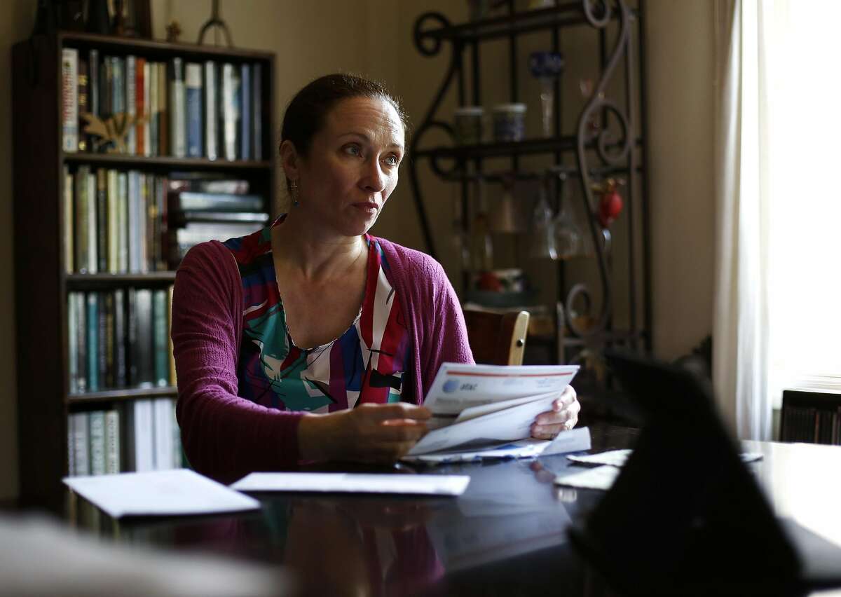 Pascale Leroy looks up at her husband Robert Bell while going through some of their healthcare-related paperwork in their home in San Francisco, California, on Thursday, May 5, 2016.
