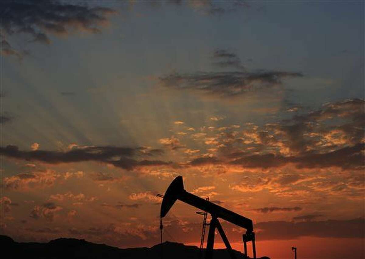 FILE - In this Dec. 13, 2015 file photo the sun sets behind an oil pump in the desert oil fields of Sakhir, Bahrain. Oil futures spiked briefly on Monday, Jan. 4, 2016, after the news that Saudi Arabia would cut diplomatic ties with Iran, a development that could be seen as a threat to oil supplies. Investors quickly discounted those fears, however. (AP Photo/Hasan Jamali, File)