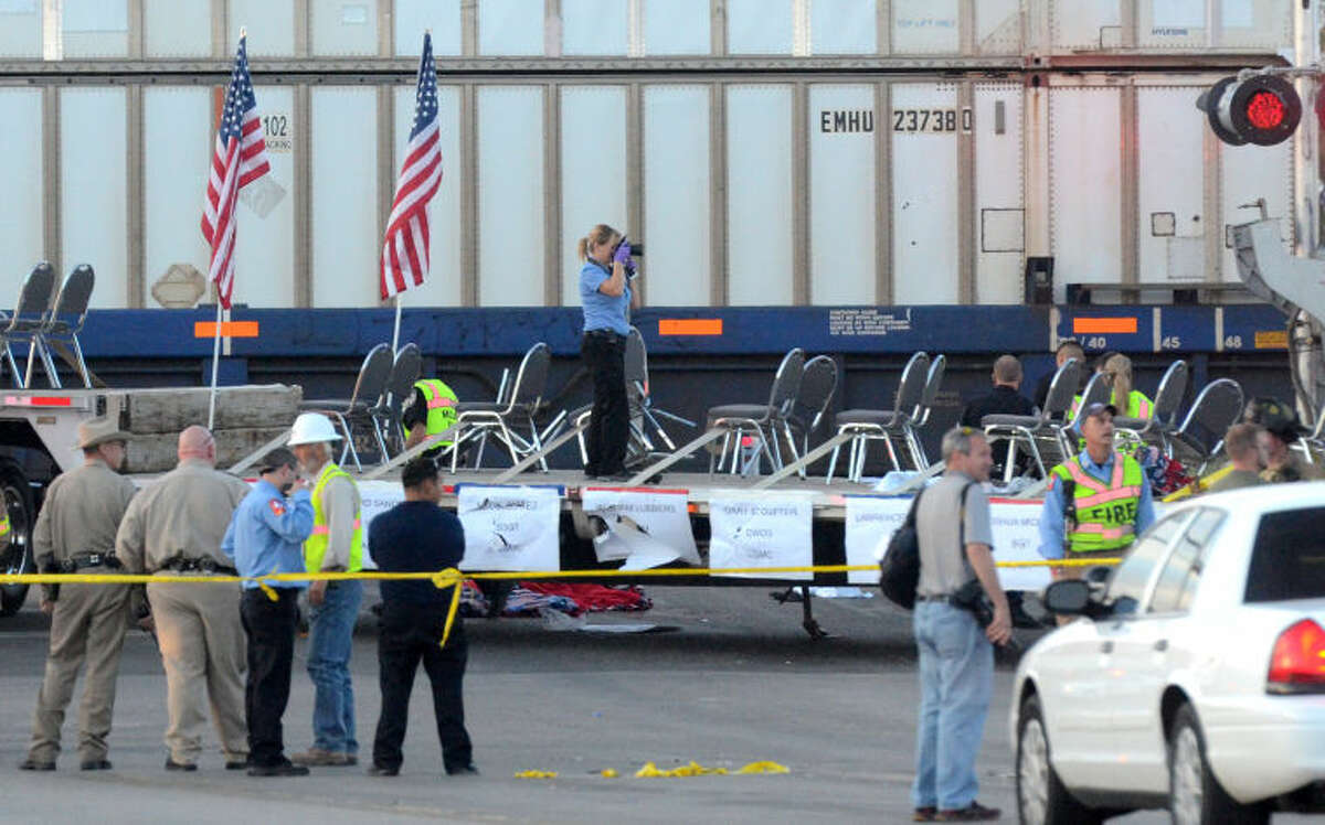 PREVIOUSLY UNRELEASED FILE PHOTO / Public safety personnel investigate the scene after a flatbed truck carrying wounded veterans and their families was struck by a train on the Garfield St. crossing during the Show of Support parade Nov. 15 in Midland, killing four and injuring 14. James Durbin/Reporter-Telegram