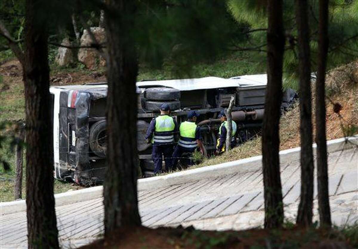 This photo courtesy of El Heraldo de Honduras newspaper shows a bus on its side along the highway between the town of San Juancito and the capital city of Tegucigalpa, Honduras, Wednesday, Jan. 13, 2016. Two New York college students and a U.S. health-care worker died Wednesday in this Central American nation when their bus crashed while taking them to the airport to fly home after a volunteer mission helping poor Hondurans. (El Heraldo de Honduras via AP)