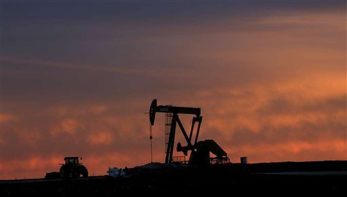 In this photo made Monday, Dec. 22, 2014, a well pump works at sunset on a farm near Sweetwater, Texas. At the heart of the Cline, a shale formation once thought to hold more oil than Saudi Arabia, Sweetwater is bracing for layoffs and budget cuts, anxious as oil prices fall and its largest investors pull back. (AP Photo/LM Otero)
