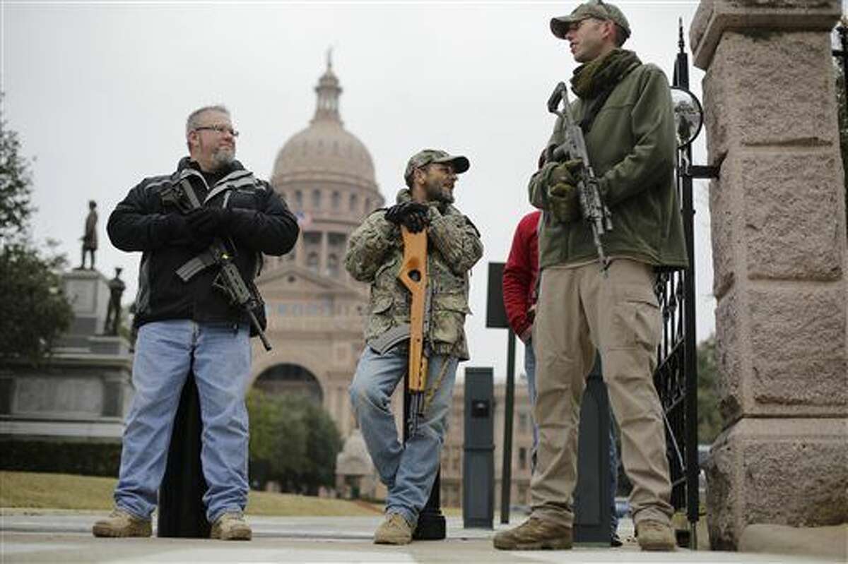 FILE - In this Jan. 13, 2015 file photo, gun rights advocates carry rifles while protesting outside the Texas Capitol in Austin, Texas. Although Texas has more than 800,000 concealed handgun license holders, it is one of only six states that don’t allow open carry, a ban that dates almost to the Civil War. But open carry looked primed to pass this year with strong support from Gov. Greg Abbott and other top Republicans who have dominated state politics for two decades. (AP Photo/Eric Gay, File)