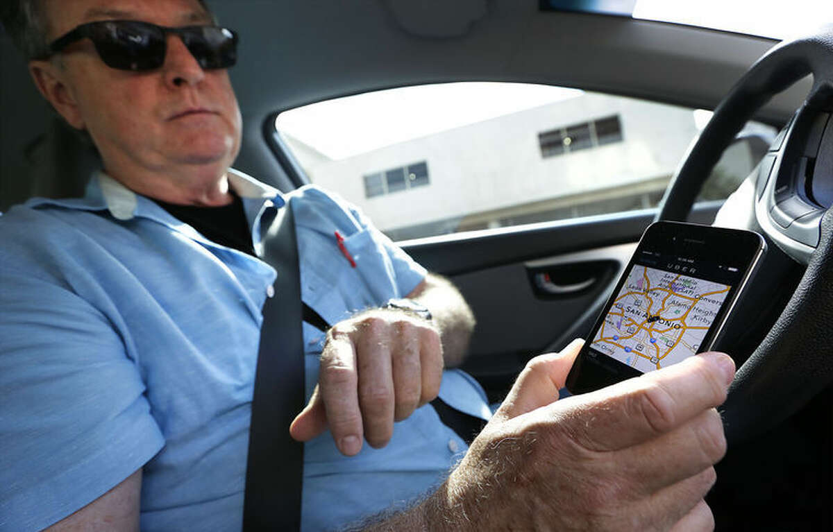 Dale Blankenship, an Uber driver, receives Uber calls over a smart phone app. Wednesday, Oct. 8, 2014.