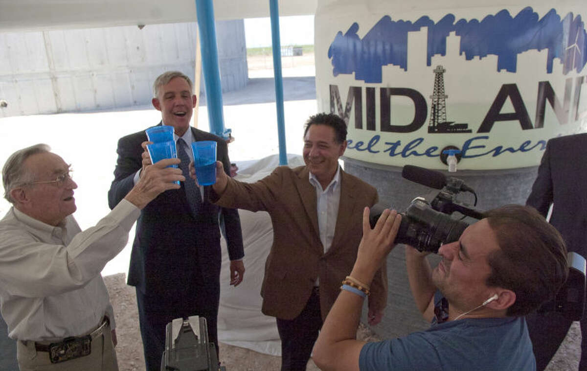 (File Photo) From left, former mayor Ed Magruder, Mayor Wes Perry, and Jose Cuevas, president of the Midland County Fresh Water Supply District No. 1speaks sample the water for the first time during the T-Bar ribbon cutting ceremony Friday at the elevated storage tank near 191 and 1788. James Durbin/Reporter-Telegram
