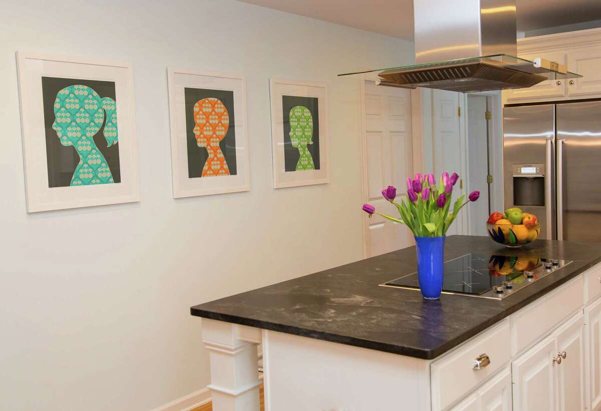 A sleek contemporary kitchen gets a pop of color from a trio of modern silhouettes by Ridgefield artist Antonio Munoz.