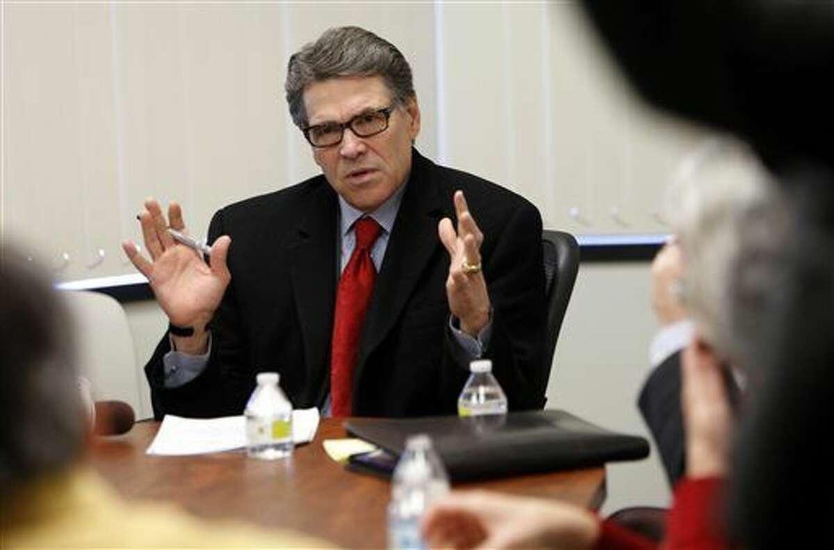 Former Texas Gov. Rick Perry talks with area business leaders, Wednesday Feb. 11, 2015, in Bedford, N.H. The former 2012 presidential hopeful told them he’s “just warming up” when he arrived in freezing cold New Hampshire and said he’s carefully preparing for a possible presidential campaign. (AP Photo/Jim Cole)