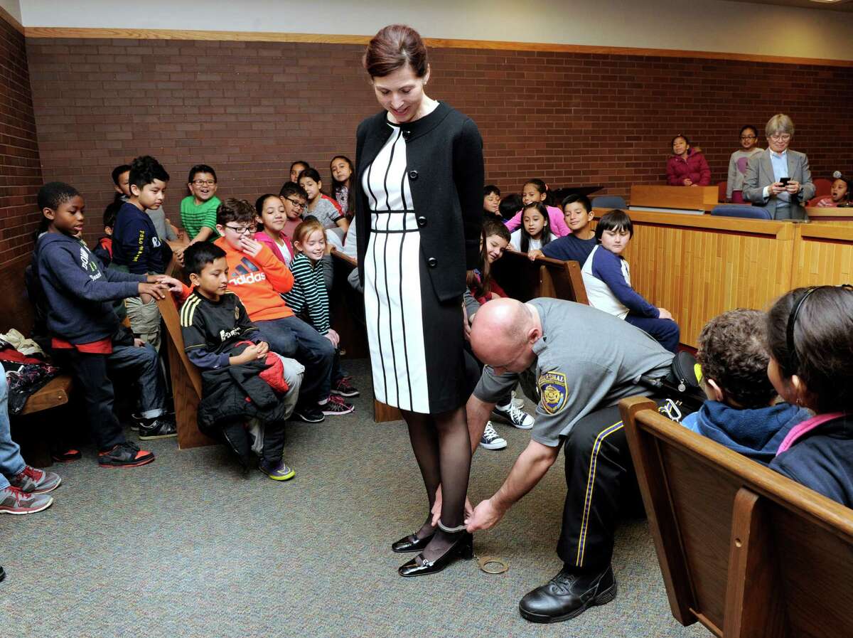 Attorney Wendy Grispin, has leg shackles locked on her by Marshall Todd Bennison during a demonstration for Third-graders from Ellsworth Avenue Elementary School. The kids were given a tour of the court asl part of the annual Law Day ceremony held at the state Superior Court in Danbury.