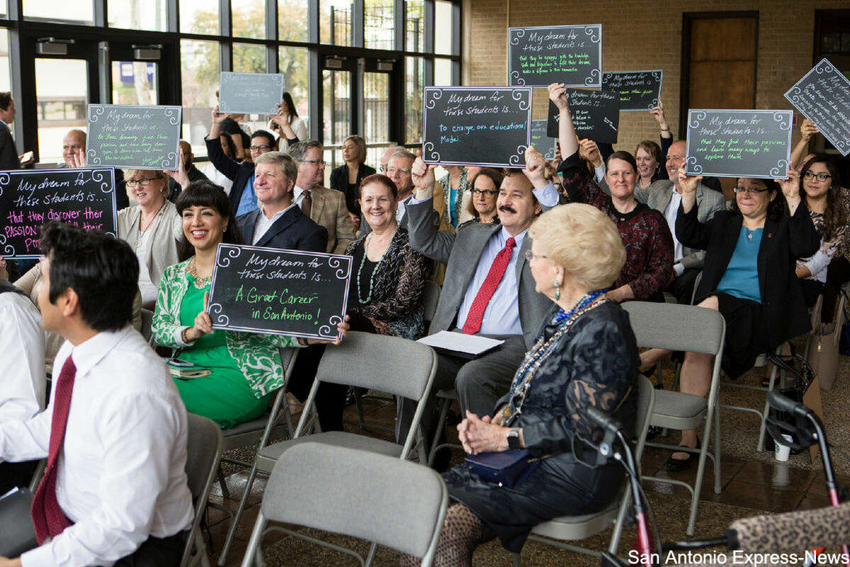 People hold up signs Tuesday morning, March 8, 2016 during the San Antonio Independent School District's announcment that next year it will open the first pre-kindergarten through 12th-grade accelerated learning academy in a San Antonio traditional public school district. that tell the students what they wish for them at the new academy. SAISD is partnering with Trinity University for the program, which is being funded by City Education Partners, a newly formed nonprofit.