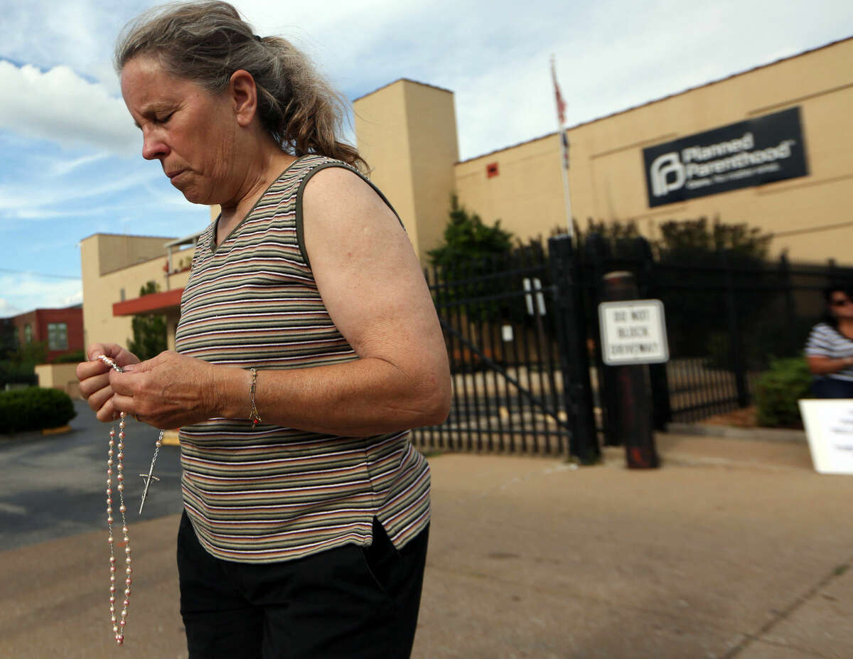 Mary Roy, of Potosi, Mo., holds a rosary in support of a pro-life rally, Tuesday, July 21, 2015, outside a Planned Parenthood building in St. Louis. Anti-abortion activists on Tuesday released a second undercover video aimed at discrediting Planned Parenthood's procedures for providing fetal tissue to researchers. (Laurie Skrivan/St. Louis Post-Dispatch via AP)
