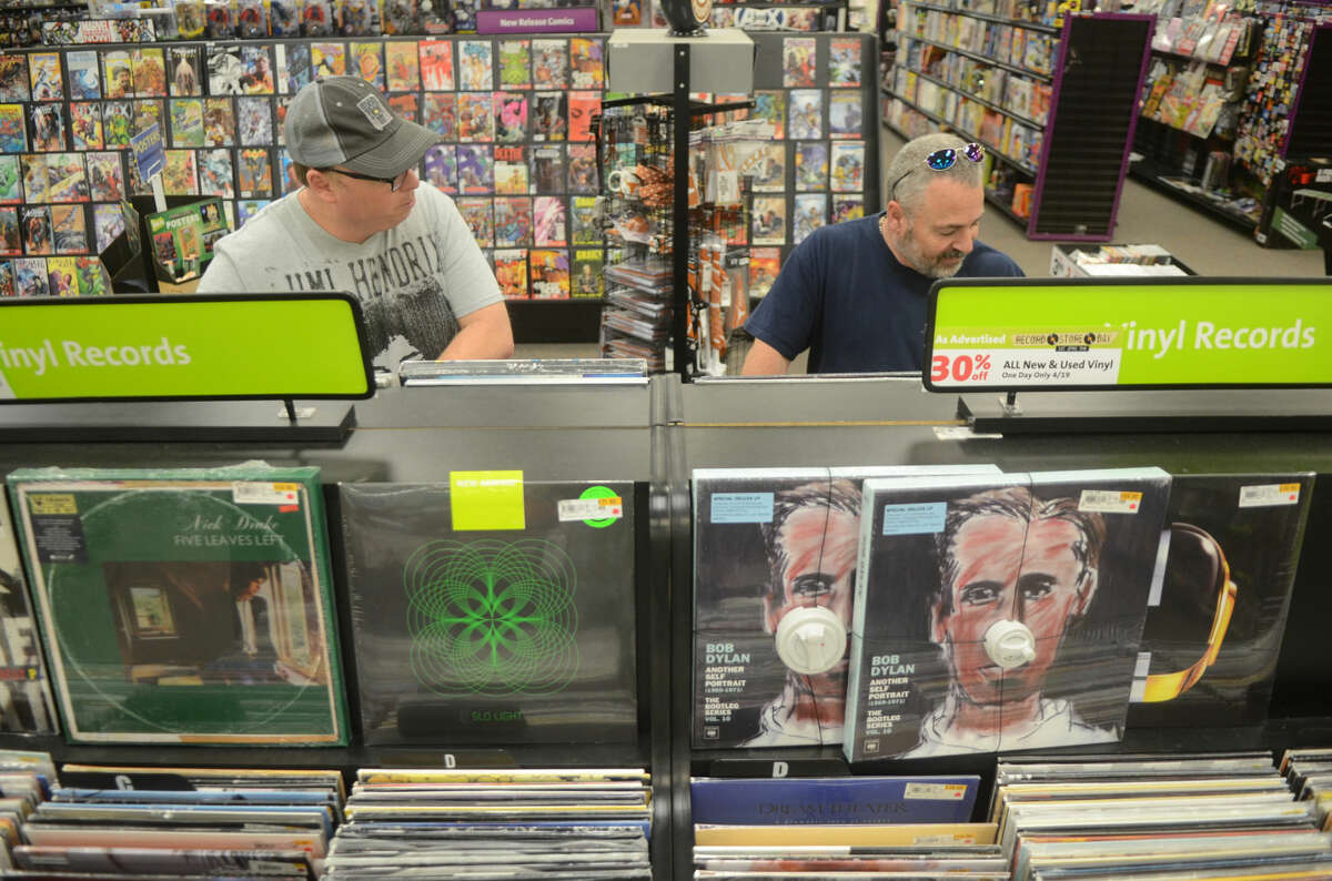 Matt Walsh of Midland, left, and Tony Priest of Crane, right, peruse vinyl records at Hasting's during National Record Store Day on Saturday. James Durbin/Reporter-Telegram