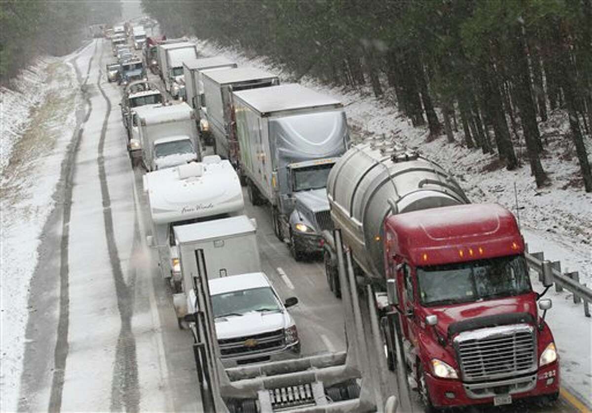 Motorists are at a standstill as emergency responders cleaned up a tractor-trailer wreck on Interstate 85 southbound near the Dinwiddie, Va. exit Monday, March 3, 2014. Winter kept its icy hold on much of the country Monday, with snow falling and temperatures dropping as schools and offices closed and people from the South and Mid-Atlantic to Northeast reluctantly waited out another storm indoors. (AP Photo/The Progress-Index, Patrick Kane)