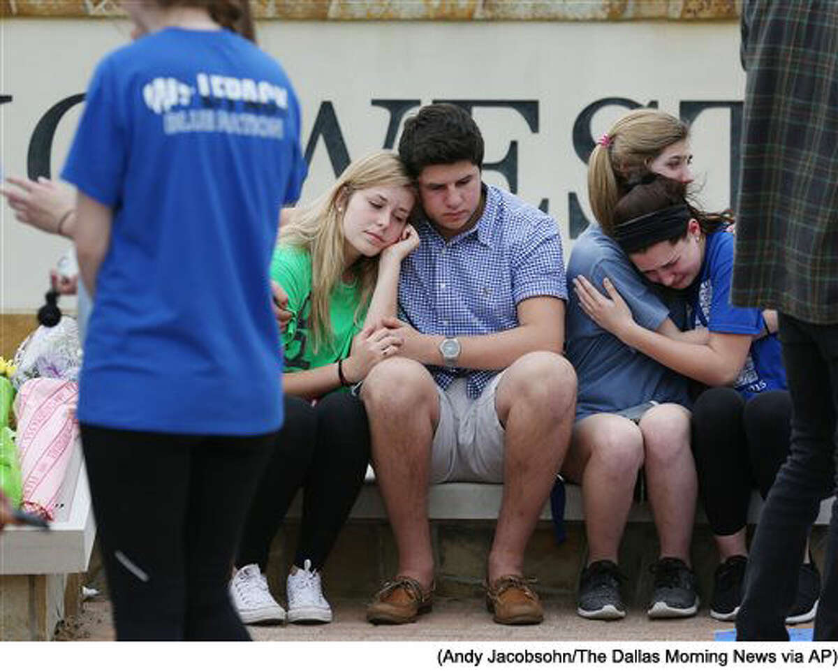 In a Friday April 8, 2016 photo, students grieve during a memorial for Plano West student Josiah Utu, 17, at Plano West High School in Plano, Texas. Josiah's brother, McCann Utu, 19, is accused of killing Josiah and their mother, Stacy Fawcett. McCann early Friday, before mortally wounding himself. (Andy Jacobsohn/The Dallas Morning News via AP)