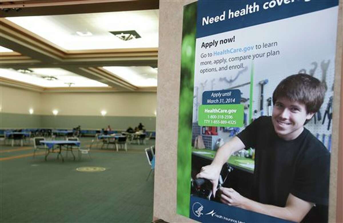 A poster touting health insurance hangs on a door to a nearly empty room at a convention center in Texas City, Texas, Saturday, March 1, 2014. Though organizers had recruited assisters to handle as many as 400 people seeking help in navigating the federal insurance marketplace, only a handful had come by in the first hours of operations. (AP Photo/Pat Sullivan)