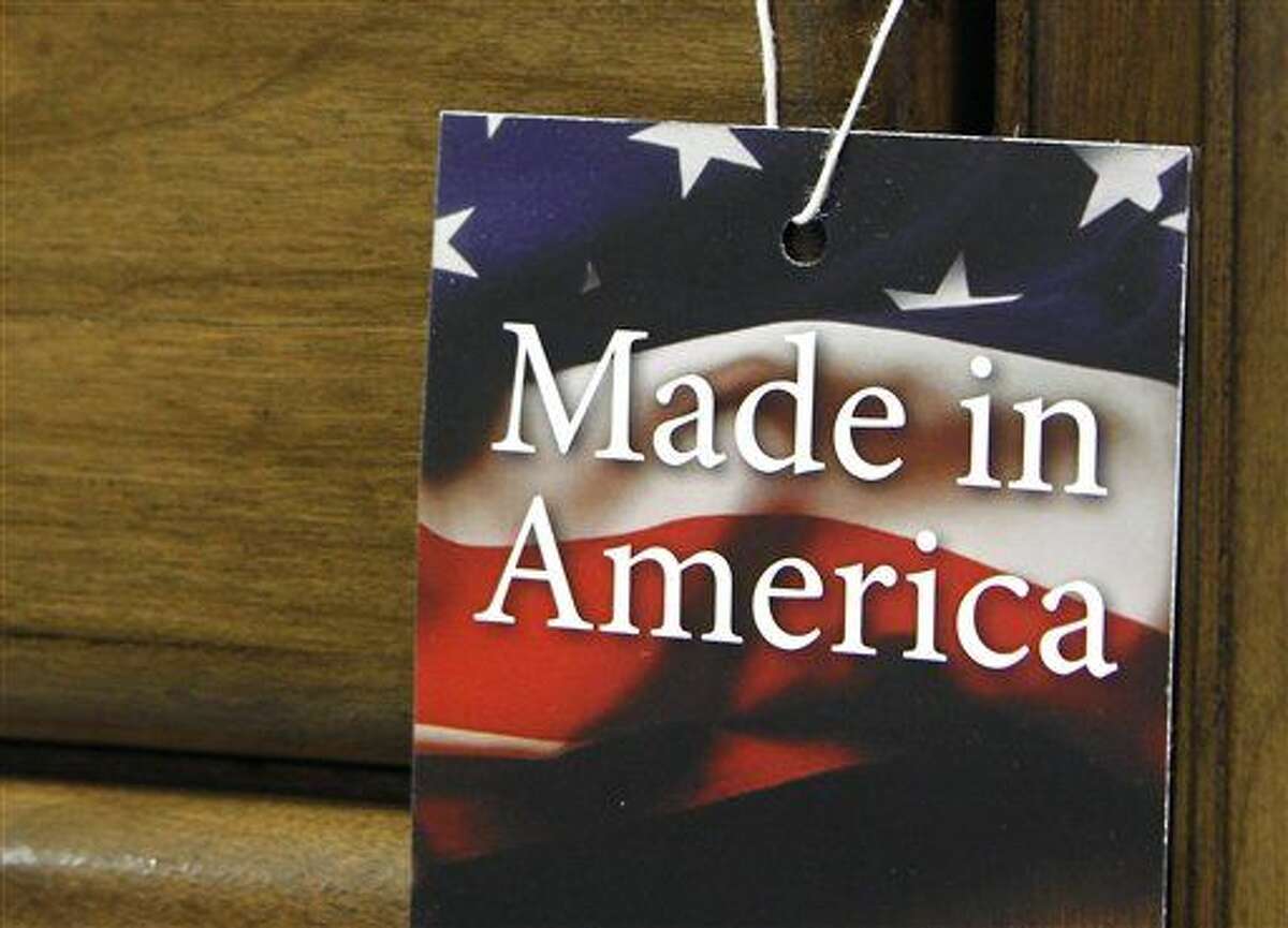 In this March 16, 2012 file photo, a "Made in America" tag hangs on a chest of drawers at a furniture factory in Lincolnton, N.C. The vast majority of Americans say they prefer lower prices instead of paying a premium for items labeled “Made in the U.S.A.,” even if it means those cheaper items are made abroad, according to an Associated Press-GfK poll. (AP Photo/Bob Leverone, File)