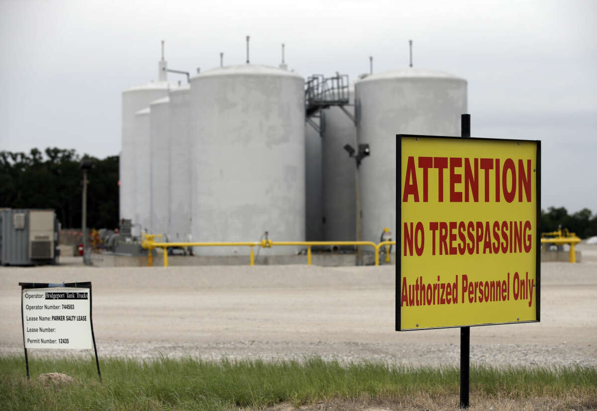 Signs warn against trespassing at a well injection site operated by Bridgeport Tank Trucks LTD., Saturday, June 21, 2014, in Azle, Texas. Earthquakes used to be unheard of on the vast stretches of prairie that unroll across Texas and Oklahoma. But in recent years, temblors have become commonplace. Oklahoma recorded 145 of them just between January and the start of May. (AP Photo/Tony Gutierrez)