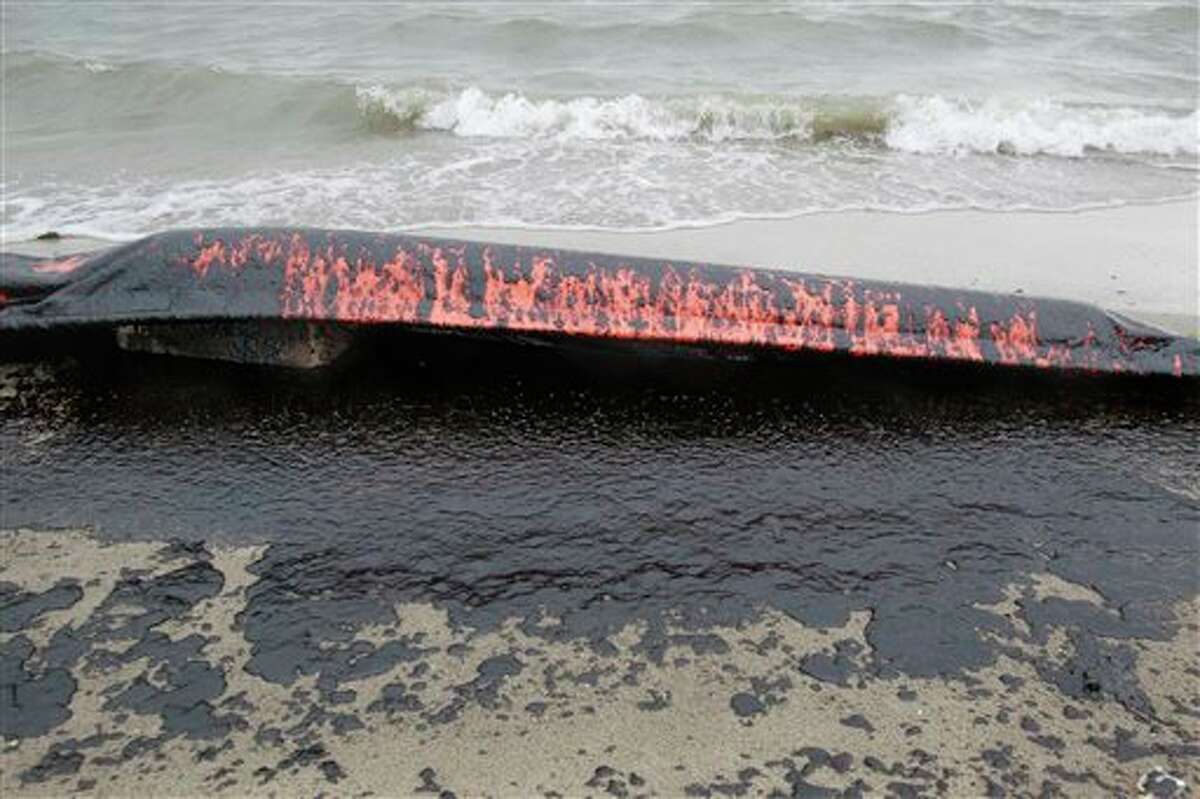 An oil containment boom is shown washed to shore on the beach area along Boddeker Rd. on the Eastern end of Galveston near the ship channel Sunday, March 23, 2014, in Galveston. (AP Photo/Houston Chronicle, Melissa Phillip)