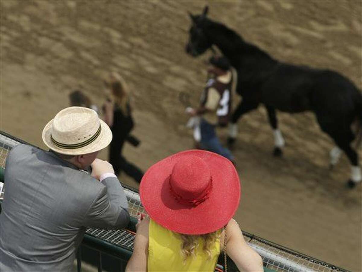 Fans watch a race before the 141st running of the Kentucky Derby horse race at Churchill Downs Saturday, May 2, 2015, in Louisville, Ky. (AP Photo/Charlie Riedel)