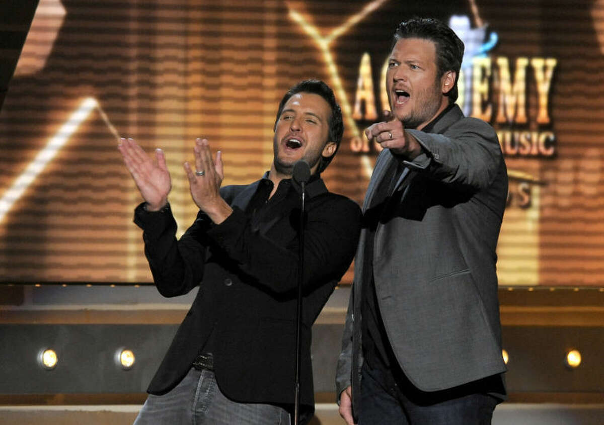 FILE - In this April 7, 2013 file photo, Luke Bryan, left, and Blake Shelton speak on stage at the 48th Annual Academy of Country Music Awards at the MGM Grand Garden Arena in Las Vegas. The 2014 Academy of Country Music Awards in Las Vegas will air live Sunday night, April 6, 2014, from 8-11 p.m. EDT on CBS. Several awards, including top honor entertainer of the year, will be announced during the broadcast, to be hosted by Blake Shelton and Luke Bryan. Shelton, Bryan, George Strait, Miranda Lambert, Jason Aldean, Keith Urban, Tim McGraw, Shakira and Stevie Nicks are scheduled to perform. (Photo by Chris Pizzello/Invision/AP, File)