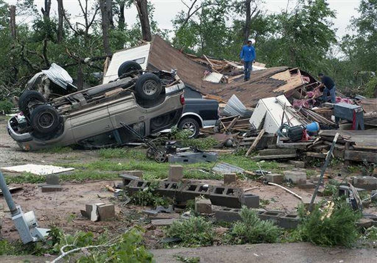 Workers survey the damage as clean-up begins Monday, May 11, 2015, in the aftermath of at least one tornado that moved through the area on Sunday, May 10, 2015, in Van, Texas. The community was reeling following a series of storms, including at least one tornado, struck the North Texas community, leaving two dead and dozens more injured or missing Sunday evening, May 10, 2015. (Andrew D. Brosig/The Tyler Morning Telegraph via AP)