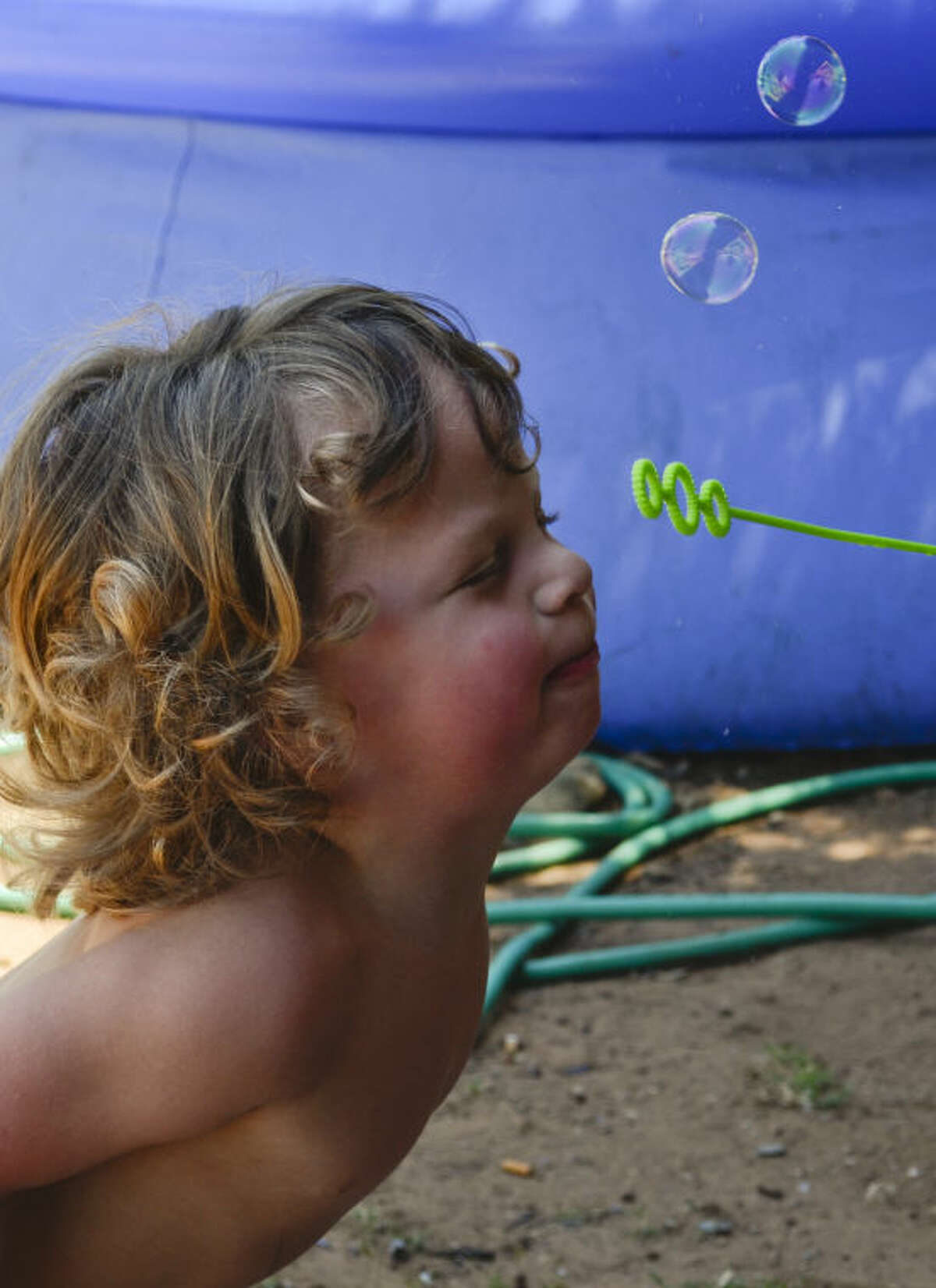 Draidyn Gage, 2, stays cool in the shade as he plays with bubbles last summer. Tim Fischer\Reporter-Telegram