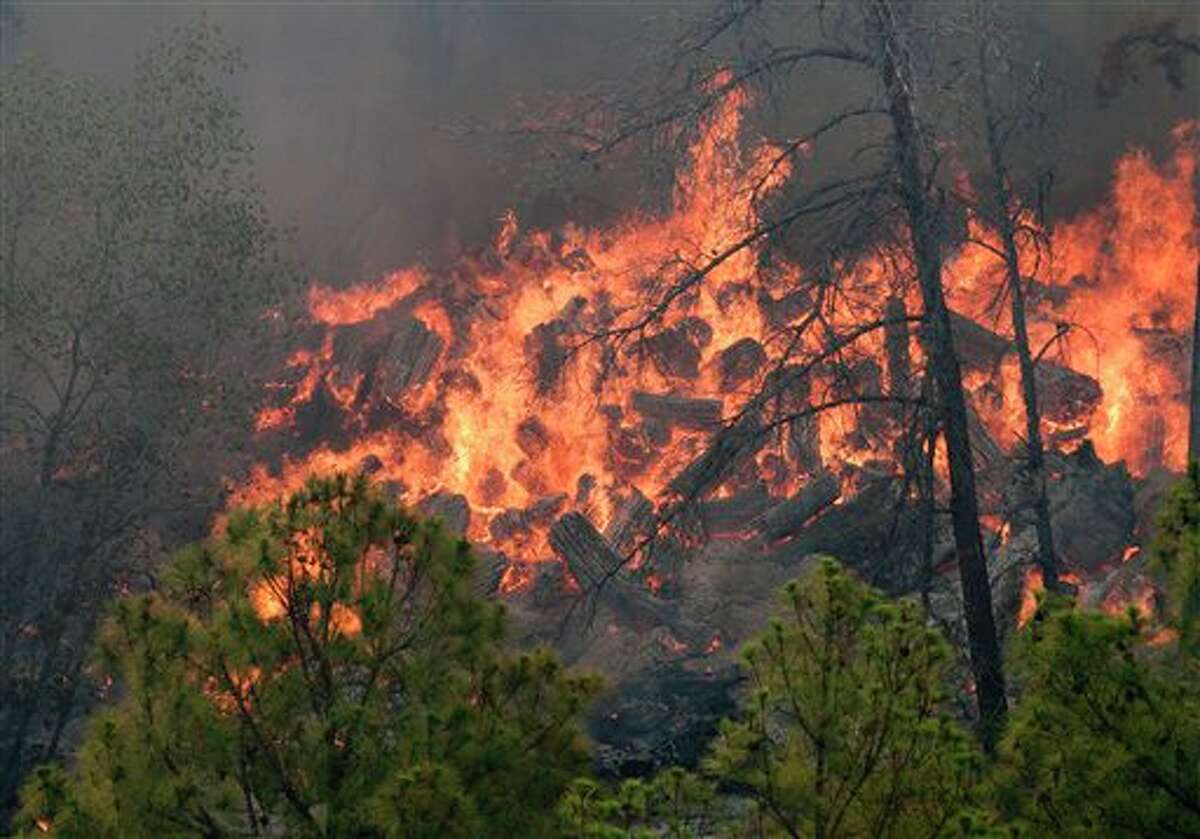 This photo provided by Texas Parks and Wildlife shows a fire burning in Bastrop State Park in Bastrop, Texas. More than 1,500 homes have been destroyed in at least 57 wildfires across rain-starved Texas, most of them in one devastating blaze near Austin that is still raging out of control, officials said. (AP Photo/Texas Parks and Wildlife Foundation, Chase A. Fountain)