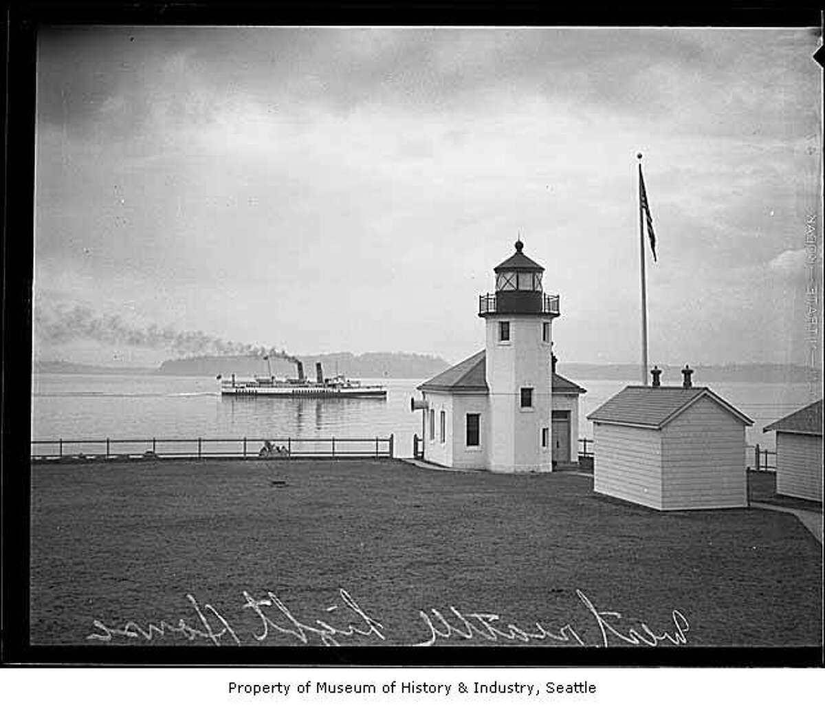 "The point of land originally known as Sma-Qua-mooks and Point Roberts was low and hard to see from a ship, so the need for a guiding light became evident. By 1858, the place was called Battery Point, and a single kerosene lantern was hung on the lonely shore by members of Hans Hanson's family. In 1887, the U.S. Lighthouse Service recognized the need for a stronger light, so they took over the task and erected a 10-foot brass post lantern. A new lighthouse station, including a small stucco building with a brick tower at the end of the point, began operating in 1913. The structure remains today." -MOHAI. Photo, dated 1931, courtesy MOHAI, Seattle P-I Collection, image number 1986.5.7176.1.