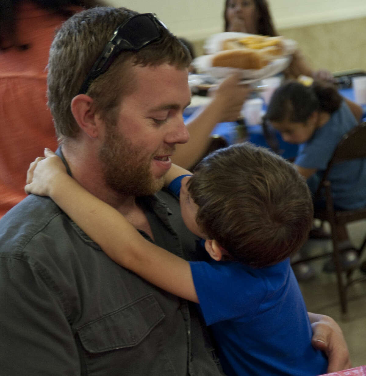 Jake Dolen gets a hug from his son, Braddox Putnam Friday at the Camp Fire USA Father's Day luncheon.