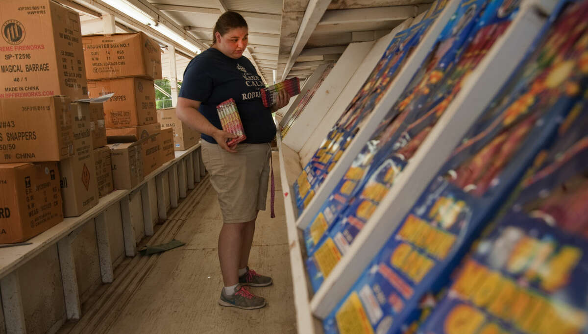 Marissa Rodriquez helps put fireworks on the stands Tuesday, 6-23-15, as she and others prep Mr. W Fireworks stand off S. Big Spring for sales starting today. Tim Fischer\Reporter-Telegram