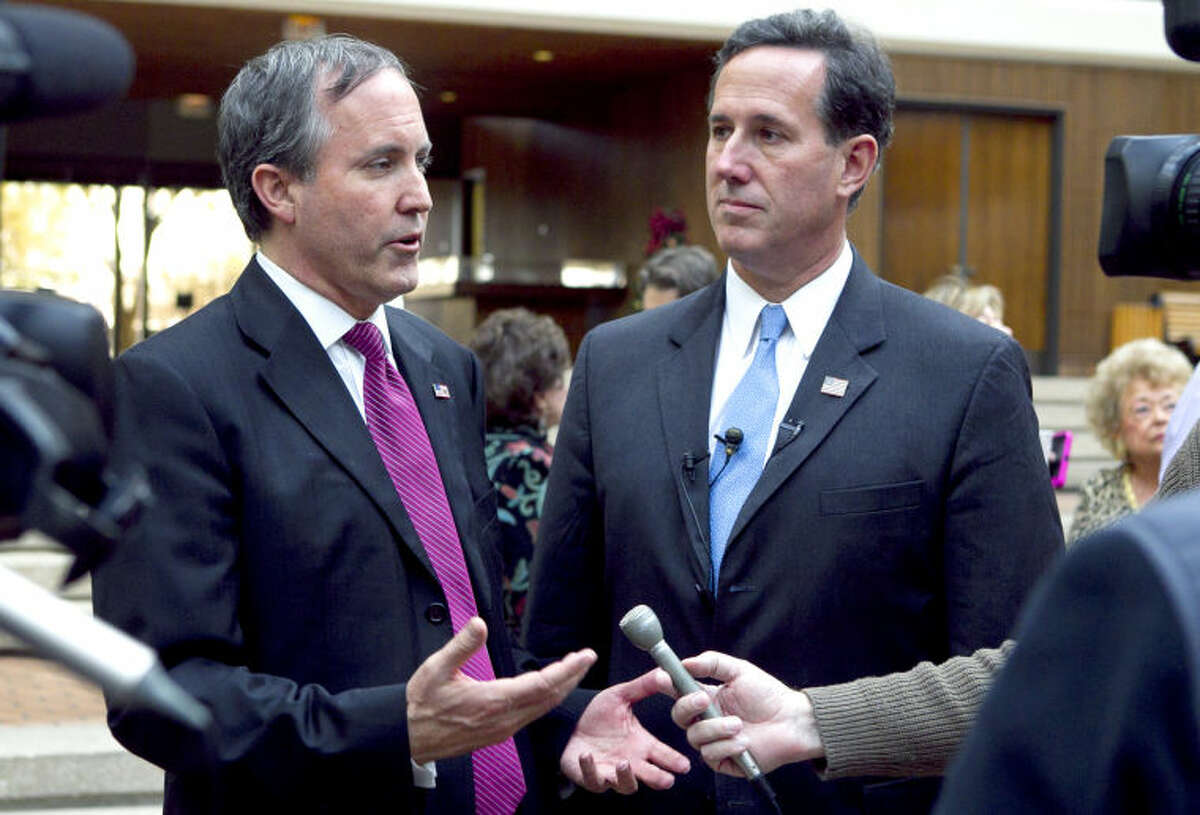 Attorney General candidate Ken Paxton (left) and Sen. Rick Santorum (right) speak to the media during a meet and greet event in the ClayDesta lobby last year. James Durbin/Reporter-Telegram