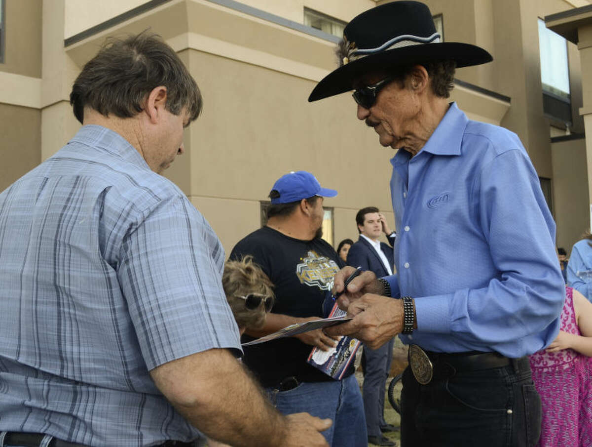 Richard Petty signs autographs Monday after flying in to meet up with his son, Kyle Petty, who rode into town with 200 other motorcycle riders on a cross country trip to raise money for Victory Junction Camp on the Kyle Petty Charity Ride. Tim Fischer\Reporter-Telegram