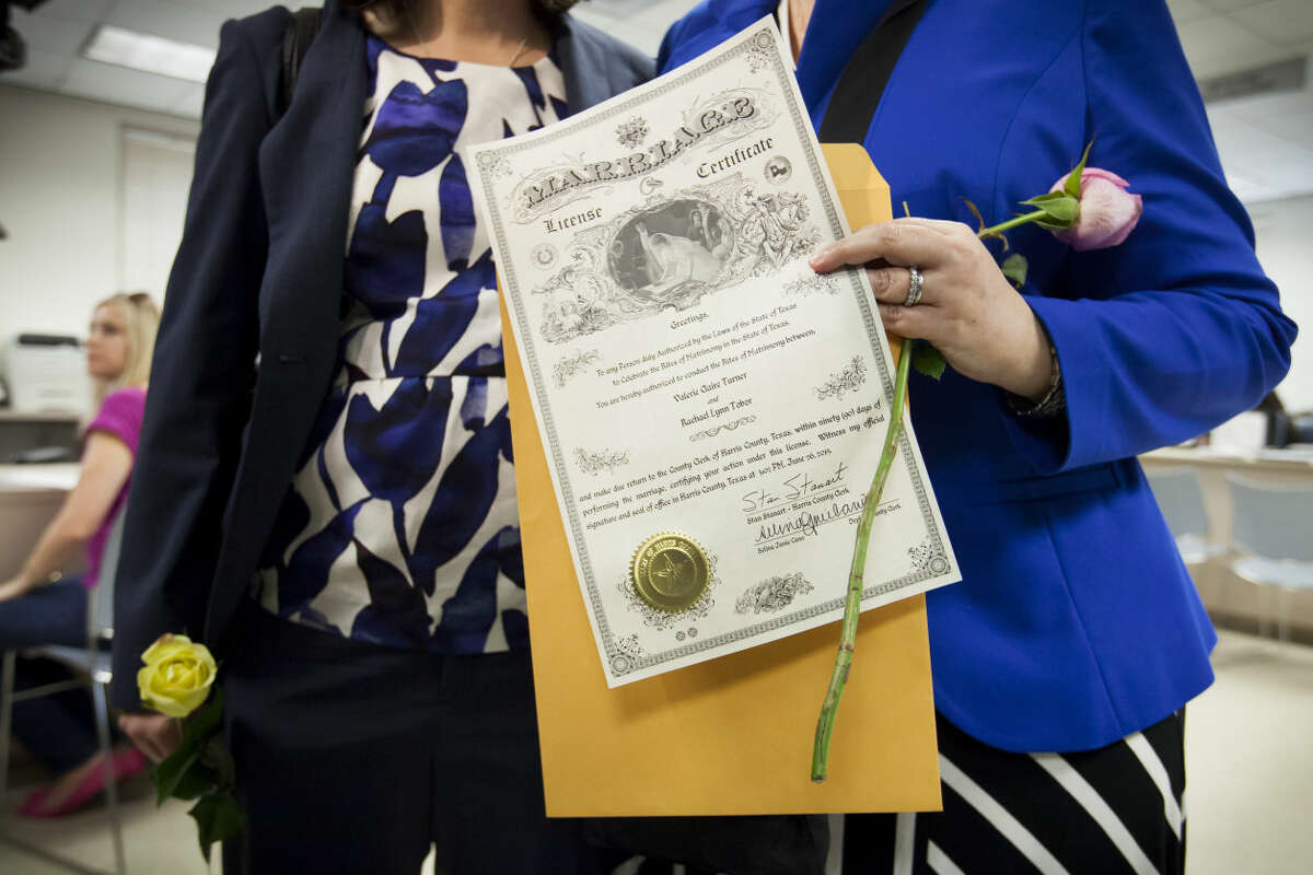 Valerie Turner and Rachael Tobor show their certificate after they were the first couple to get handed their marriage license at the Harris County Courthouse in Houston, June 26, 2015. In a long-sought victory for the gay rights movement, the Supreme Court ruled Friday that the Constitution guarantees a nationwide right to same-sex marriage. (Michael Stravato/The New York Times)