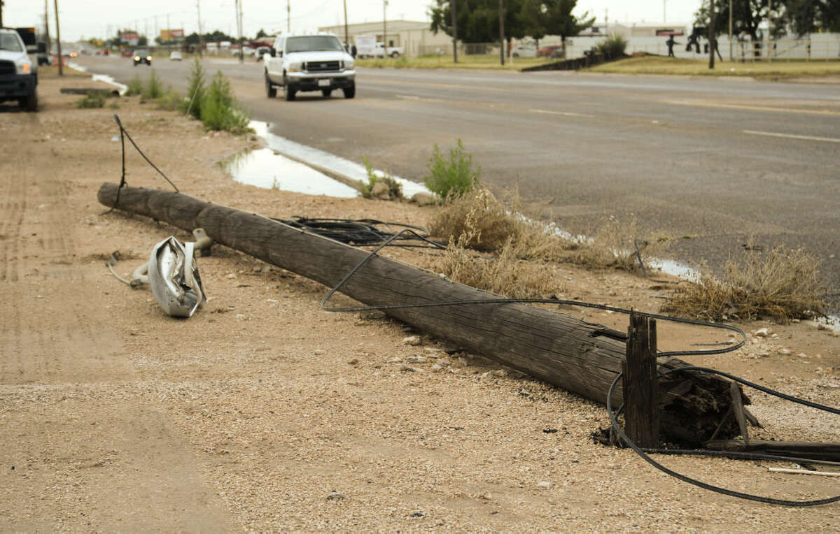 Storms that blew through early Tuesday, 6-30-15, knocked down power poles on S. Midkiff leaving many businesses and homes without phones and internet. Tim Fischer\Reporter-Telegram