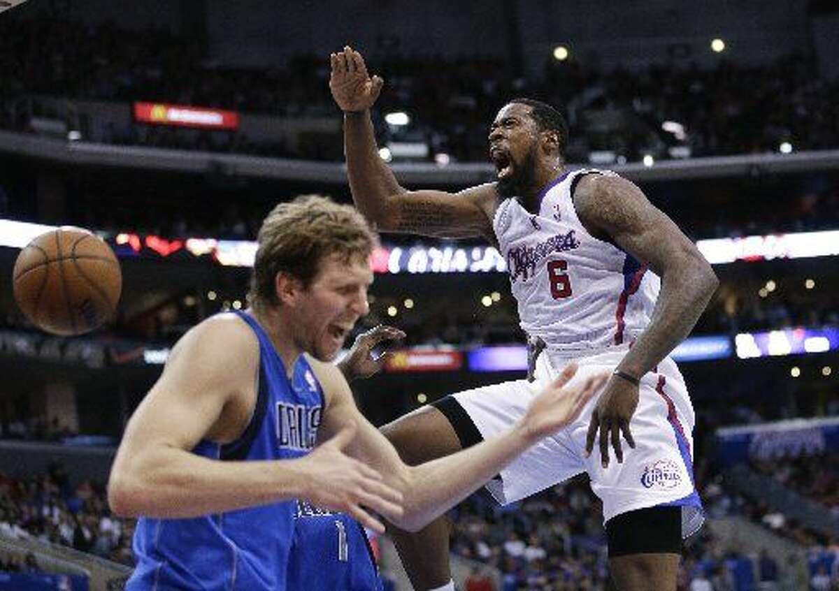 In this April 3, 2014, file photo, Los Angeles Clippers' DeAndre Jordan, right, screams after making a dunk in front of Dallas Mavericks' Dirk Nowitzki during the first half of an NBA basketball game in Los Angeles. The fallout from DeAndre Jordan's decision to spurn the Dallas Mavericks and stay with the Los Angeles Clippers continued reverberating through the NBA on Thursday, July 9, 2015, the first day that teams and players could officially do business in the new league year. (AP Photo/Jae C. Hong, File)