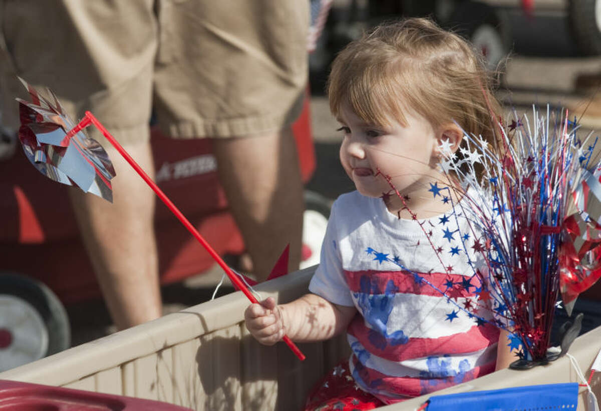 Layla Stone, 2, rides in a cart as she and others participate in the 2014 July 4th Children's Parade. Tim Fischer\Reporter-Telegram