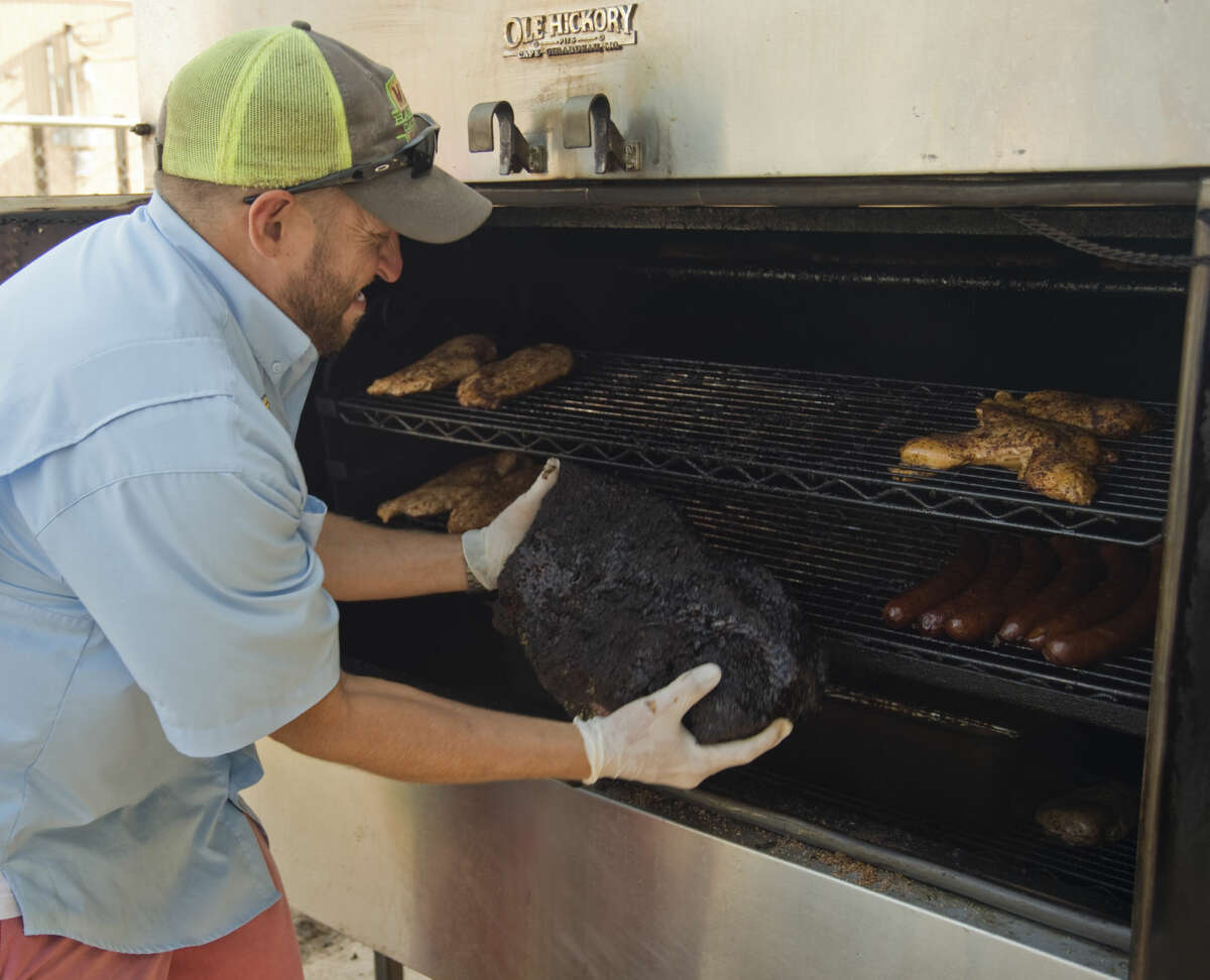 Derel Webb pulls brisket from the rotisserie smoker Thursday 7-9-15, after 20 hours of cooking as he helps get Mac's Bar-B-Q ready for the lunch crowd. Tim Fischer\Reporter-Telegram