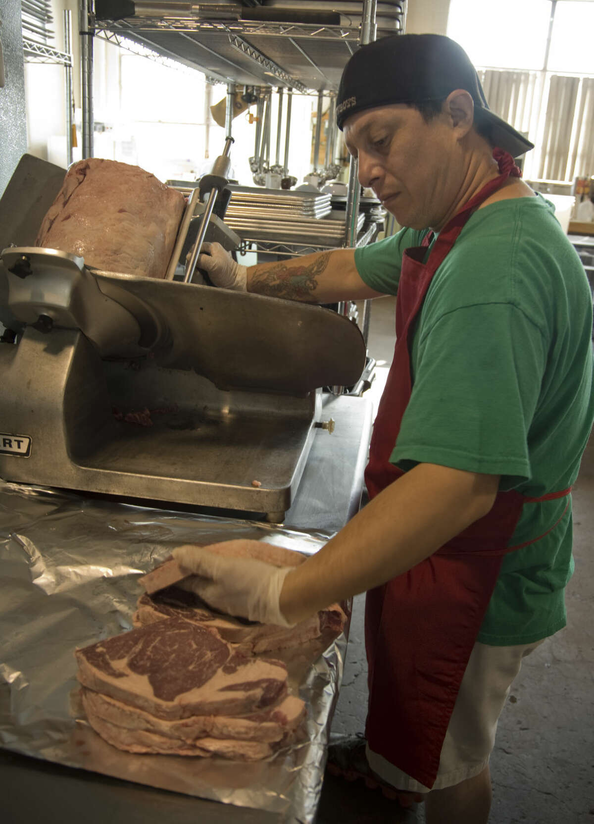 Chef Eric Medrano cuts ribeye steaks Thursday 7-9-15, as they get ready for the lunch crowd at Mac's Bar-B-Q. Tim Fischer\Reporter-Telegram