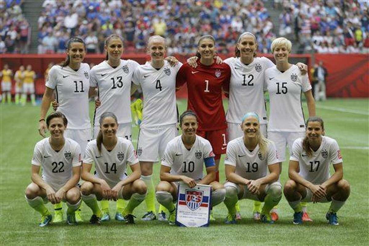 The United States Women's National Team, including goalkeeper Hope Solo (1) and midfielder Carli Lloyd (10) pose for the traditional team photo before beating Japan 5-2 in the the FIFA Women's World Cup soccer championship in Vancouver, British Columbia, Canada, Sunday, July 5, 2015. (AP Photo/Elaine Thompson)