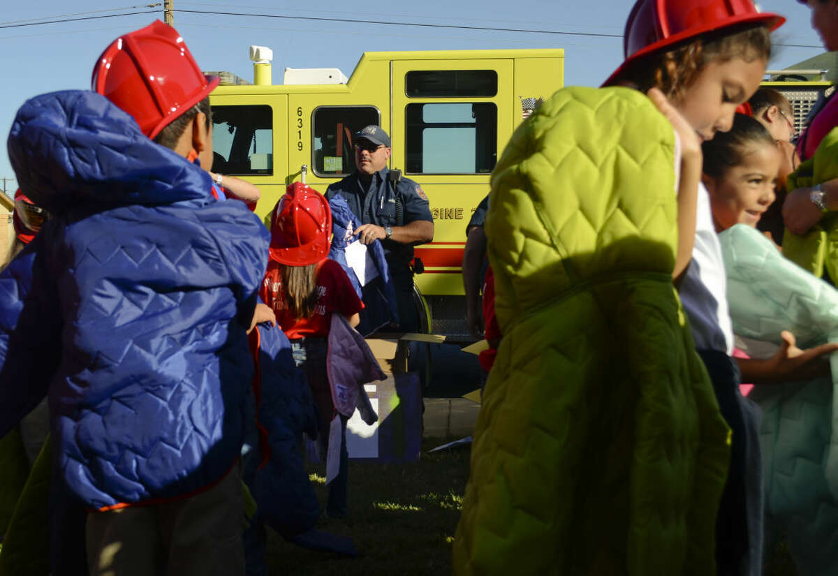 In this 2014 file photo, Midland firefighter Jeff Coleman helps hand out new winter coats to children at South Elementary. Members of the Professional Firefighters Association gave out more than 185 new coats to all children at South Elementary in k-2. Tim Fischer\Reporter-Telegram